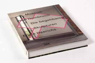 Dieser Bildband gibt einen Überblick über die begehbaren Skulpturen von Erwin Heerich. Ein geschlossenes Buch auf einem Tisch, mit einem einfachen Cover-Design. Der Titel ist deutlich sichtbar und das Buch scheint in gutem Zustand zu sein, bereit zum Lesen oder zur Aufbewahrung in einer Bibliothek.