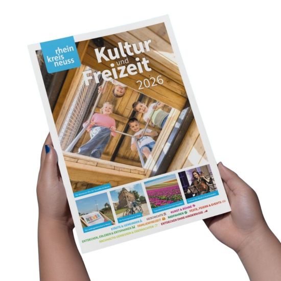 Das Bild zeigt das Titelblatt des Kultur- und Freizeitführers für den Rhein-Kreis Neuss 2026. Es zeigt spielende Kinder auf einer Holzkonstruktion, eine Landschaftsgartenschau, die Festungsmauer in Zons, ein Tulpenfeld und eine Musikerin. Verschiedene Schlagworte wie Städte, Geschichte, Kunst, Familienfreizeit, Radfahren und Feste werden hervorgehoben.