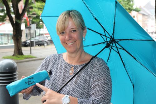 Eine Frau mit einem Regenschirm in der Farbe Türkis