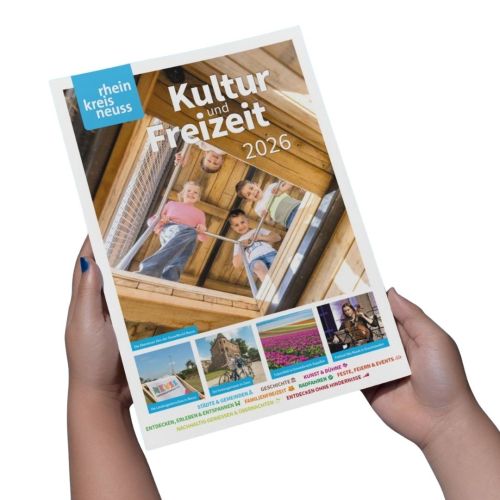 Das Bild zeigt das Titelblatt des Kultur- und Freizeitführers für den Rhein-Kreis Neuss 2026. Es zeigt spielende Kinder auf einer Holzkonstruktion, eine Landschaftsgartenschau, die Festungsmauer in Zons, ein Tulpenfeld und eine Musikerin. Verschiedene Schlagworte wie Städte, Geschichte, Kunst, Familienfreizeit, Radfahren und Feste werden hervorgehoben.